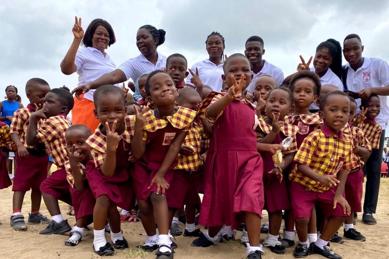 Rayliza Academy pupils in school uniform posing happily together with their teachers