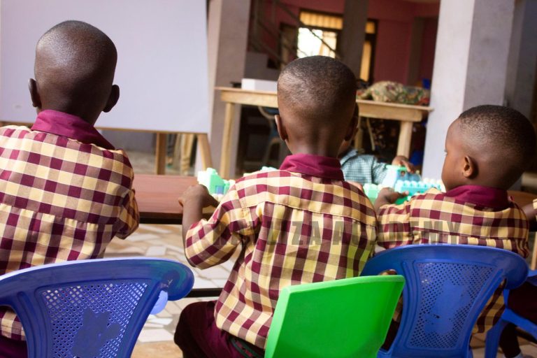 Young learners seated together at a classroom table with learning materials
