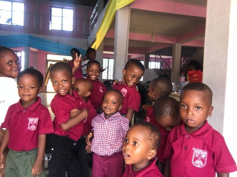 Pupils in maroon school polo shirts smiling together