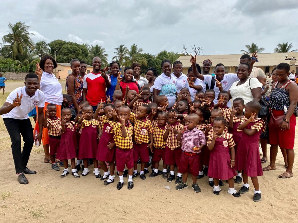 Rayliza Academy pupils and teachers gathered together outdoors on the school grounds
