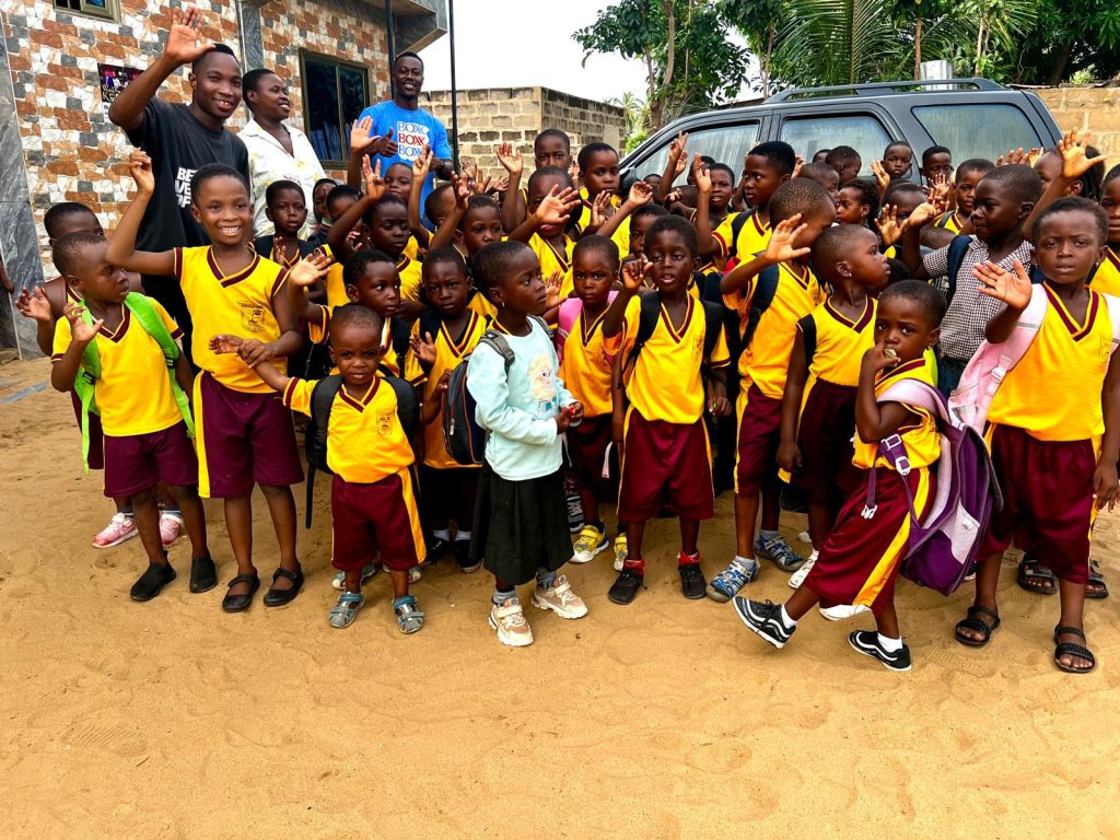 Pupils in yellow and maroon house colours gathered outdoors at Rayliza Academy